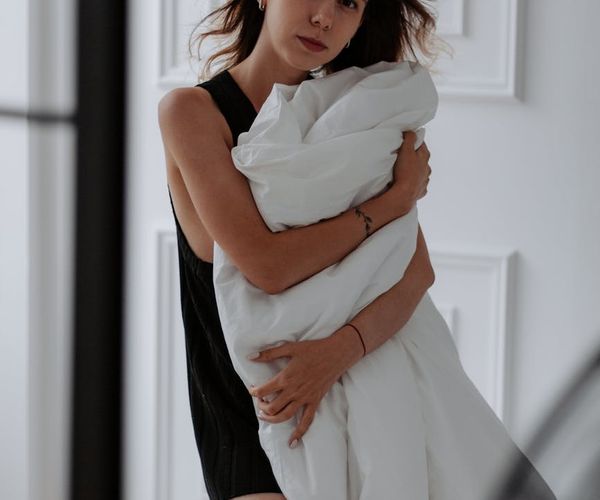 Elegant woman in a serene yoga pose, bathed in soft morning light.